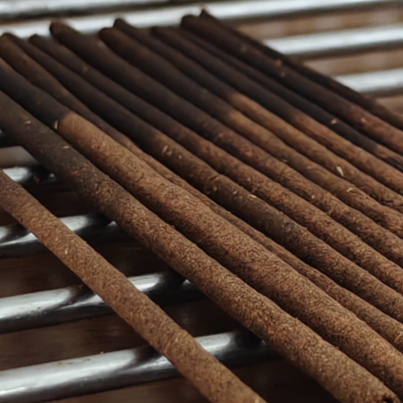 Freshly hand-rolled Cense incense sticks laid out to dry on a rack