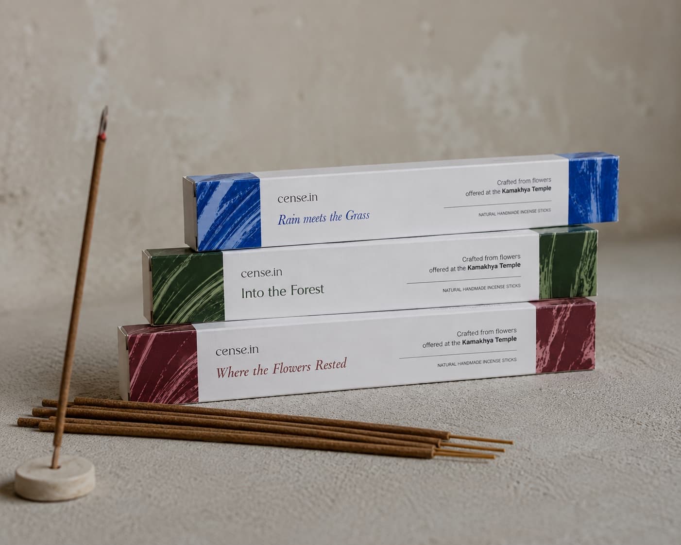 All three Cense incense boxes stacked together with loose sticks and a holder